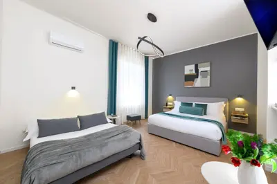 a bedroom with two beds and a table at Tolu Relais in Rome