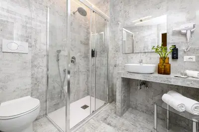 a bathroom with a shower and a toilet and a sink at Tolu Relais in Rome