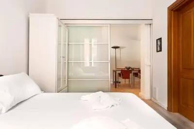 a bedroom with a white bed and a table at Confalonieri Place by Oneup Hospitality in Rome