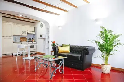 a living room with a black leather couch and a table at Monti Suite with charming Terrace in Rome