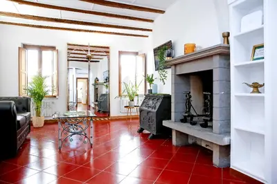 a living room with a fireplace and a red tile floor at Monti Suite with charming Terrace in Rome