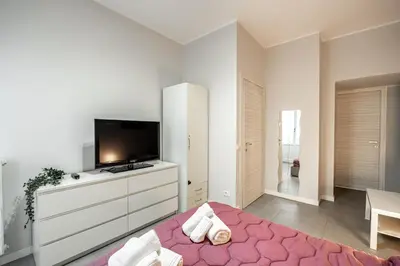 a bedroom with a bed and a flat screen tv at MagicHouse 2 Camere 2 Bagni -15 min Colosseo in Rome