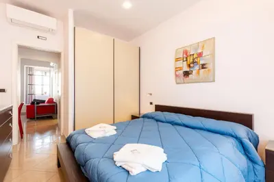 a bedroom with a blue bed with towels on it at Lungotevere Aventino House by ACS HOLIDAYS in Rome