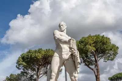 a statue of a man standing next to trees at Farnesina Rooftop Terrace in Rome