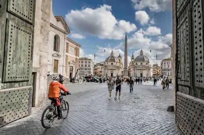 a man riding a bike on a city street at Farnesina Rooftop Terrace in Rome