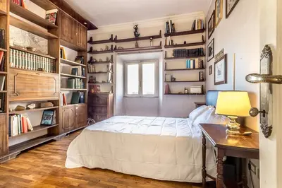 a bedroom with a bed and a desk and bookshelves at Roman Holiday Repubblica in Rome