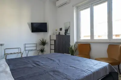 a bedroom with a bed and two chairs and a tv at The Roma Flat- private parking & direct bus to Vatican City in Rome