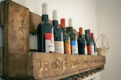 a wooden shelf with a bunch of wine bottles at The Roma Flat- private parking & direct bus to Vatican City in Rome