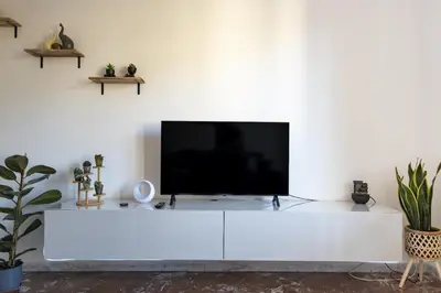 a white entertainment center with a flat screen tv on top at The Roma Flat- private parking & direct bus to Vatican City in Rome