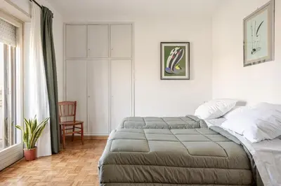 a bedroom with a bed and a chair and a window at Francis house in Rome