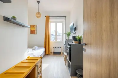 a small room with a bed and a kitchen at cRoma - guest house in Rome