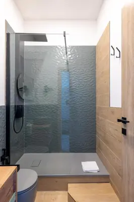 a bathroom with a glass shower with a toilet at cRoma - guest house in Rome