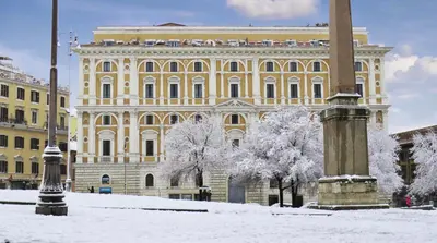 a large yellow building with snow in front of it at Princeps Boutique Hotel in Rome