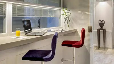 a home office with a laptop and red and purple chairs at Princeps Boutique Hotel in Rome