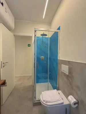 a bathroom with a glass shower with a toilet at Domus Romae in Rome