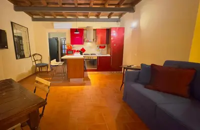 a living room with a blue couch and a kitchen at Casa dolce Casa Trastevere in Rome