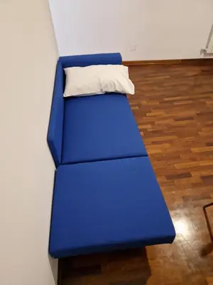 a blue couch with a pillow on top of it at appartamento monticiano in Rome
