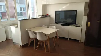 a small kitchen with a white table and a tv at Appartamento moderno con vista sul verde 2 fermate da San Pietro in Rome