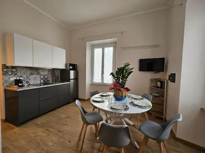 a kitchen with a table and chairs in a kitchen at You'RhomeSuite in Rome