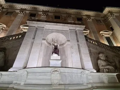 a statue in front of a building at night at You'RhomeSuite in Rome