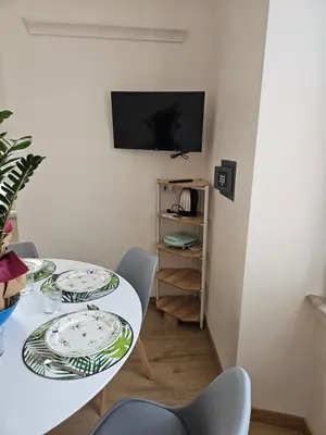 a dining room with a white table and chairs at You'RhomeSuite in Rome
