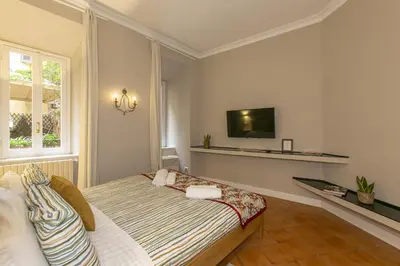 a bedroom with a bed and a tv on the wall at Home Baccina 28 in Rome