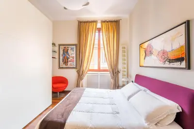 a bedroom with a large bed and a window at Dimora Esedra, Historical Flat in the Heart of Rome in Rome