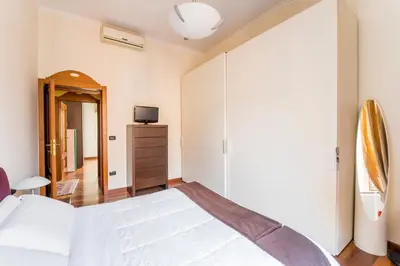 a bedroom with a large white bed and a mirror at Dimora Esedra, Historical Flat in the Heart of Rome in Rome