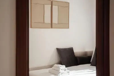 a bathroom with a bed and a sink and a mirror at Casa Incanto - Luxury Vatican Apartment in Rome