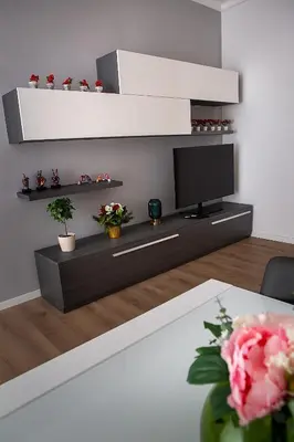 a living room with a flat screen tv and flowers at Ostiense 73 in Rome