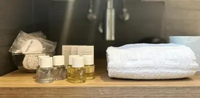 a shelf with three bottles of essential oils and a basket at AD 111 ColaDiRienzo Rooms - by AD Roma in Rome