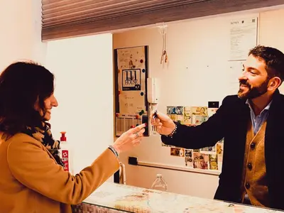 a woman taking a picture of a man in a mirror at AD 111 ColaDiRienzo Rooms - by AD Roma in Rome