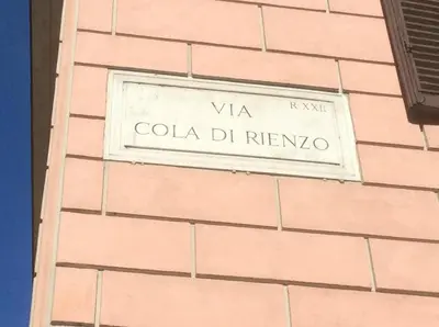 a sign on the side of a pink brick building at AD 111 ColaDiRienzo Rooms - by AD Roma in Rome