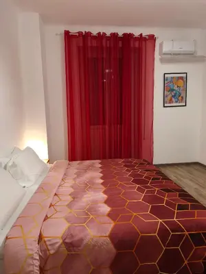 a bedroom with a large bed and red curtains at Room CasaVostrA 2 in Rome