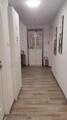 a hallway with white walls and a wooden floor at Room CasaVostrA 2 in Rome