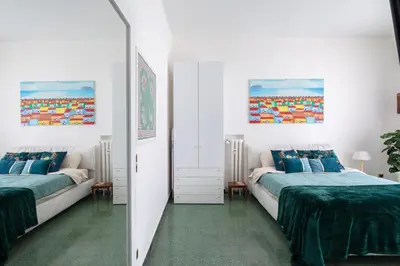 a bedroom with two beds and a mirror at ULPIANO SUITE Vaticano Centro in Rome