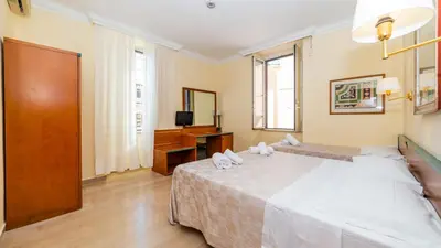 a bedroom with a large white bed and a television at Hotel Center 3 in Rome