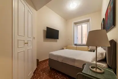 a bedroom with a bed and a lamp on a table at JOIVY Charming 3BR flat near the Vatican in Rome