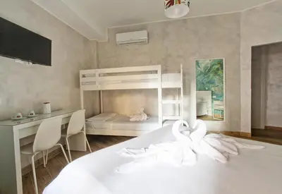 a bedroom with a bed and a desk and a bunk bed at Marble Rooms in Rome