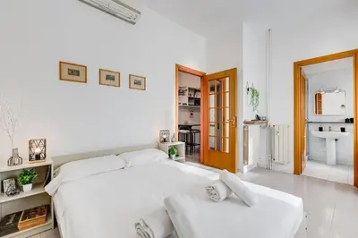 a white bedroom with a large white bed with two white pillows at Casa San Paolo in Rome