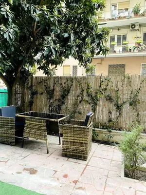 a table and chairs in front of a fence at Nina's Apartment with terrace Rome Monteverde in Rome
