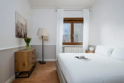 a white bedroom with a bed and a window at Zen Vatican Studio - Zen 30 in Rome