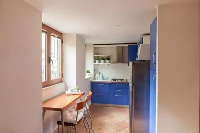 a kitchen with blue cabinets and a wooden table at Chez David in Rome