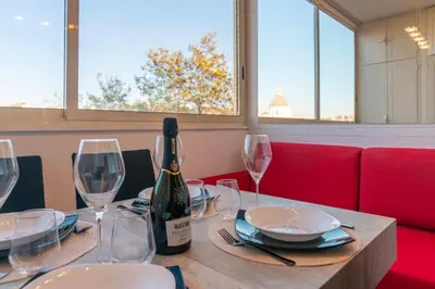 a bottle of wine sitting on a table with glasses at Aim - La Cupola - Saint Peter view apartment in Rome