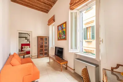 a living room with an orange couch and a television at Navona Stylish Apartment - Up to 5 People in Rome