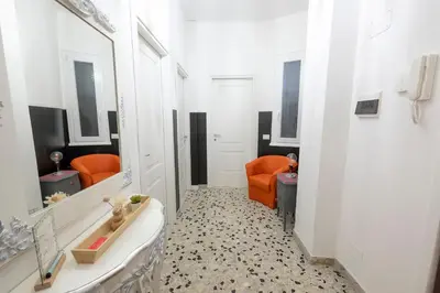 a bathroom with an orange chair and a bath tub at Olimpia House - Gianicolense in Rome