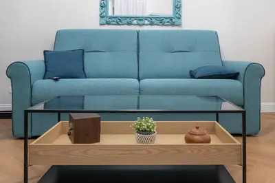 a living room with a blue couch and a coffee table at Olimpia House - Gianicolense in Rome