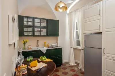 a kitchen with green cabinets and a wooden table at Emperor's View in Colosseum in Rome