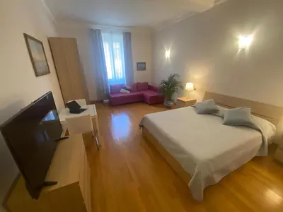 a bedroom with a bed and a tv and a couch at La Pianista sull'oceano in Rome