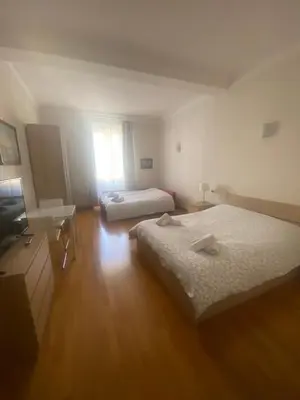 a hotel room with two beds and a television at La Pianista sull'oceano in Rome